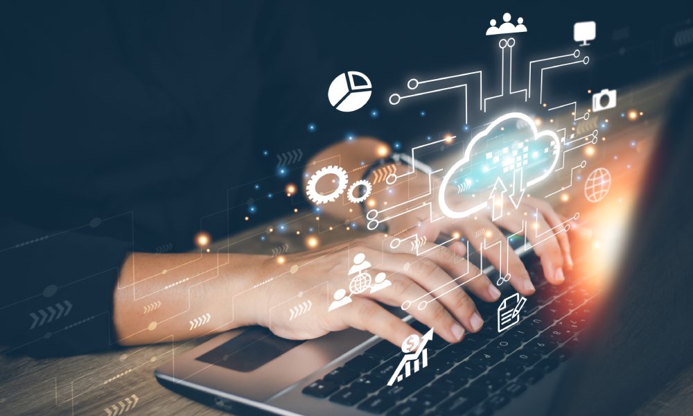 Hands typing with digital cloud graphics overlay.